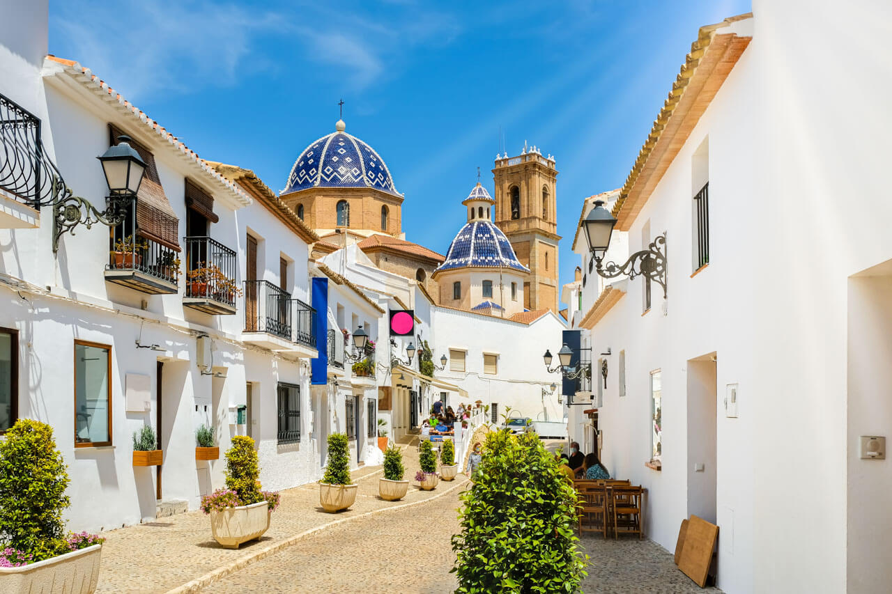 Weißgetünchte Altstadtgasse mit blauen Kuppeln, Konversation üben nach dem Unterricht
