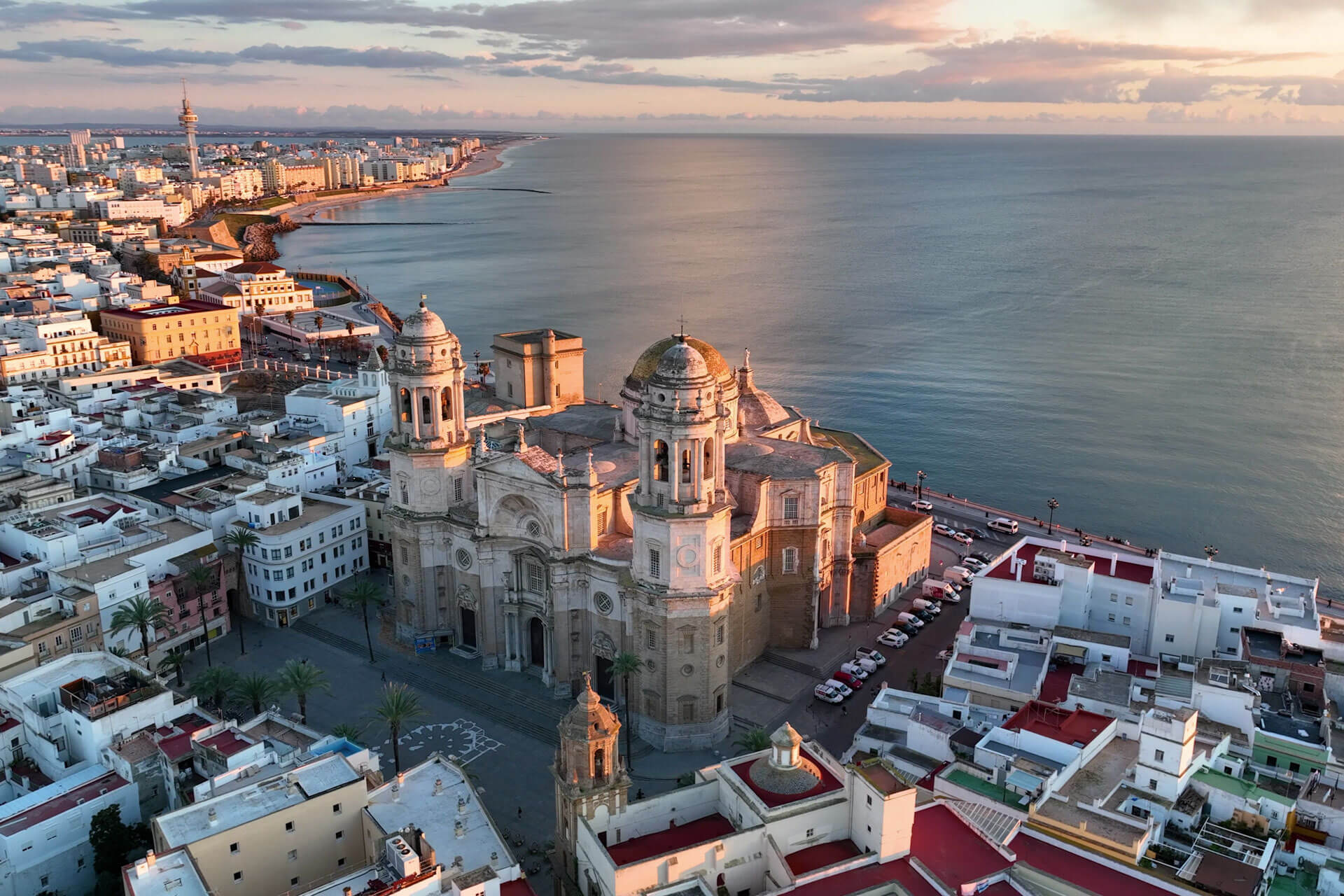 Luftbild der Kathedrale von Cádiz an der Atlantikküste im warmen Abendlicht, umgeben von der weißen Altstadt in Andalusien.
