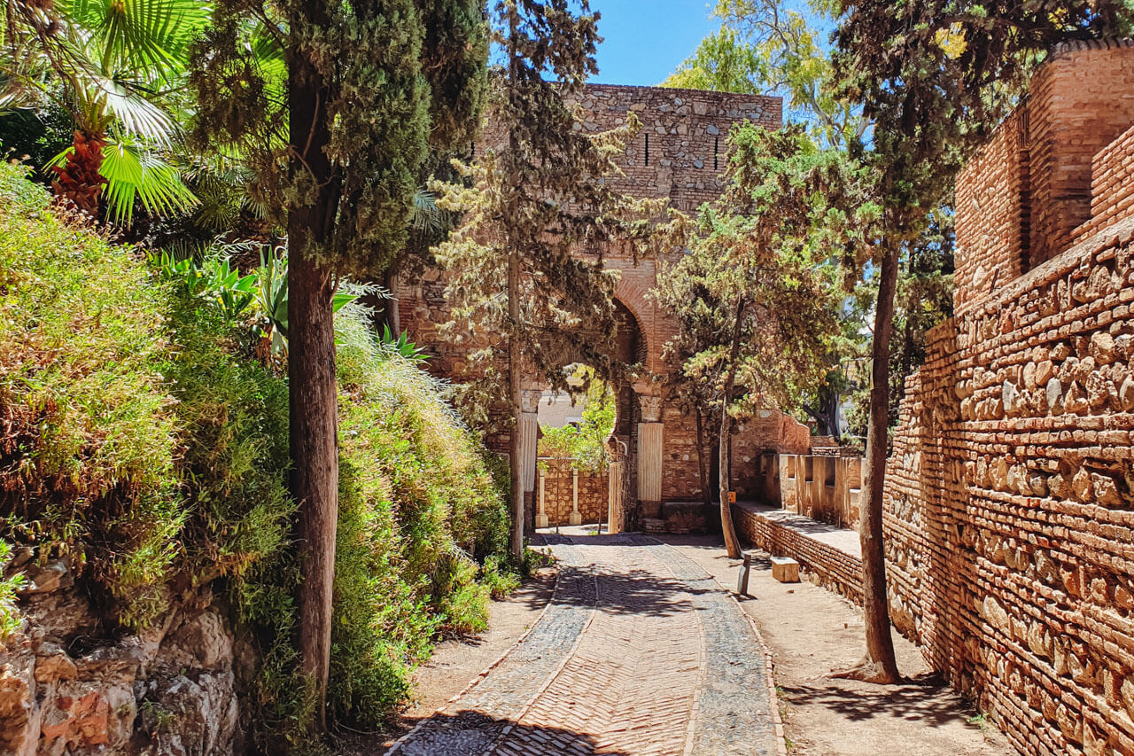 Schmale Altstadtgasse in Madrid mit farbenfrohen, dreieckigen Tüchern und Girlanden über der Straße.