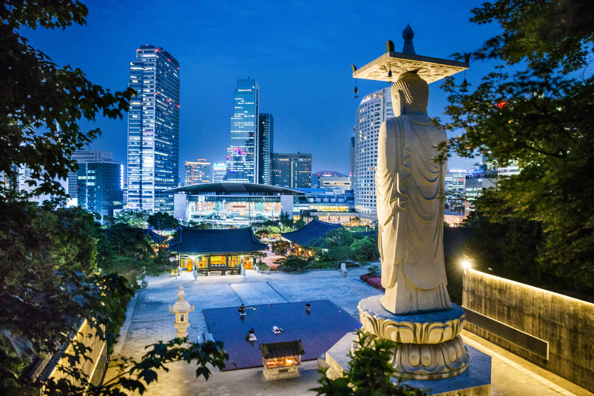 Buddhastatue mit Skyline bei Nacht Sprachreise und Hörverstehen trainieren