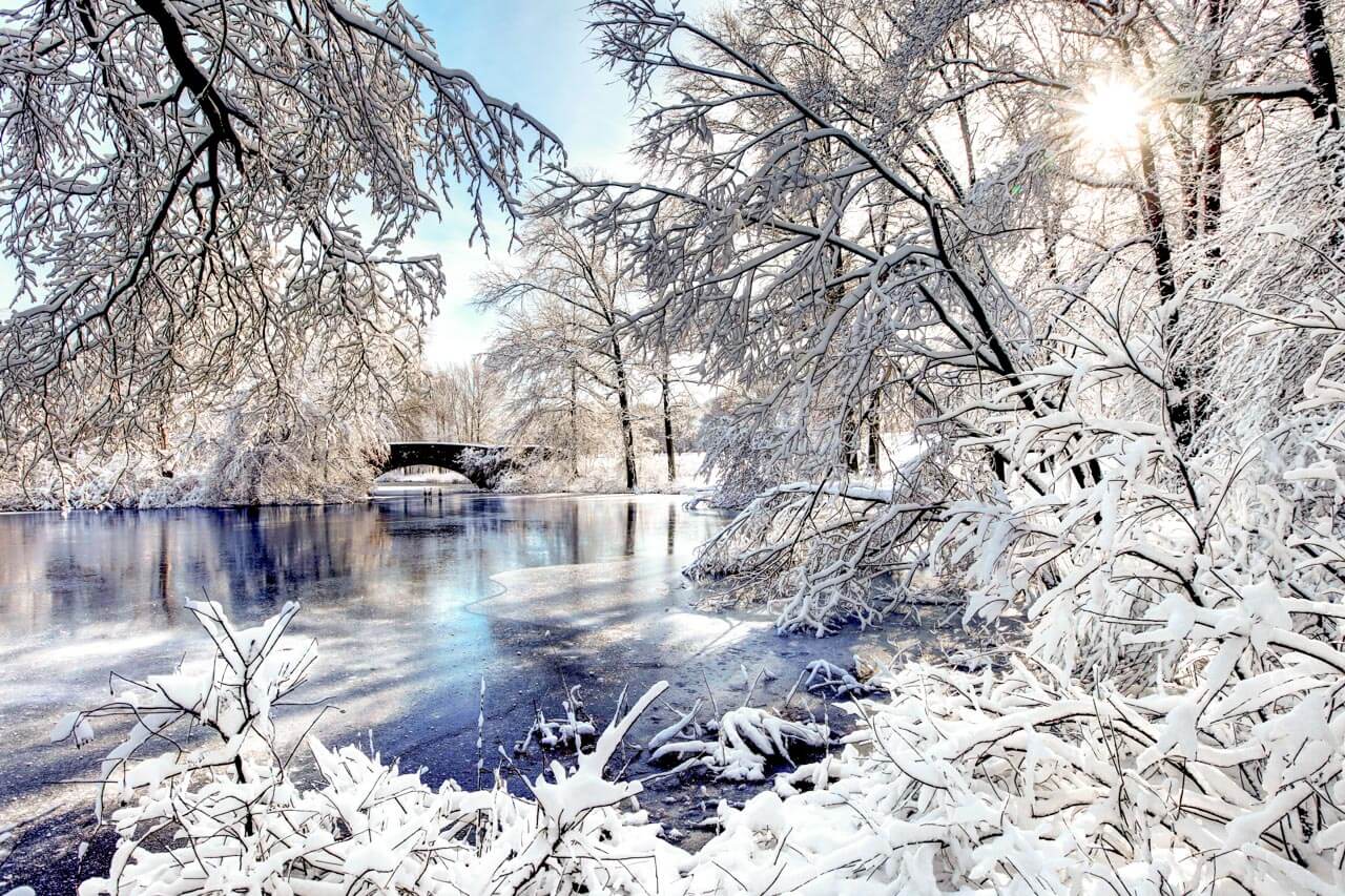 Verschneiter See mit Brücke und Wintersonne, Hörverstehen üben in ruhiger Umgebung.