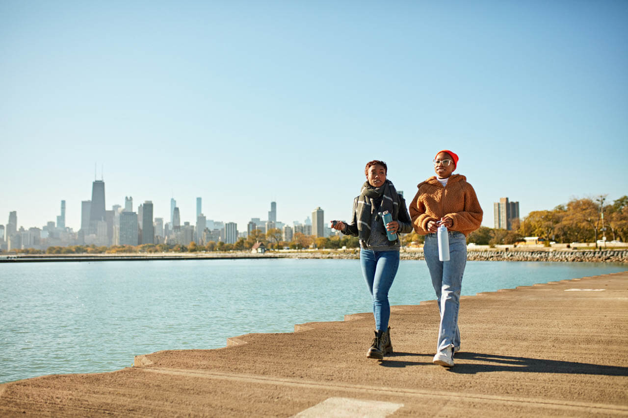Zwei Freunde am Ufer vor Skyline in Chicago, Konversation üben auf dem Spaziergang nach dem Unterricht.